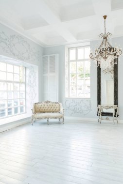 Lüks zengin oturma odası iç tasarım zarif klasik mobilyalar ve duvar süslemeleri ile. Büyük pencereli büyük ışık beyaz Oda