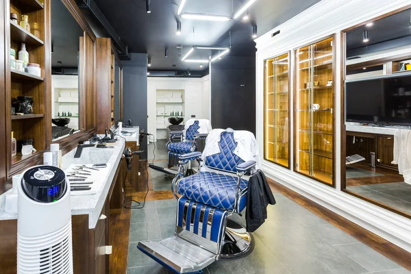 luxury barber shop interior, blue expensive furniture, wood trim, fashionable black ceiling, white robes on the backs of armchairs