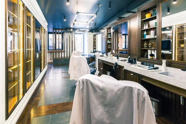 高級理髪店のインテリア 青高価な家具 木のトリム ファッショナブルな黒い天井 アームチェアの背中に白いローブ — ストック写真