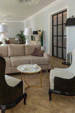 Modern bir apartman dairesi, parlak renklerde ve şık mobilyalı. Mutfak, yatak odası ve duvarsız oturma odası..