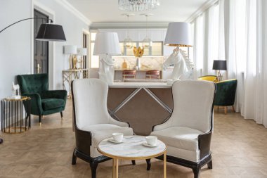 Modern bir apartman dairesi, parlak renklerde ve şık mobilyalı. Mutfak, yatak odası ve duvarsız oturma odası..