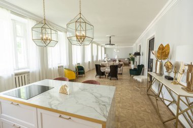 Modern bir apartman dairesi, parlak renklerde ve şık mobilyalı. Mutfak, yatak odası ve duvarsız oturma odası..