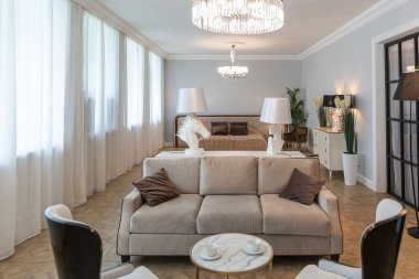 Modern bir apartman dairesi, parlak renklerde ve şık mobilyalı. Mutfak, yatak odası ve duvarsız oturma odası..