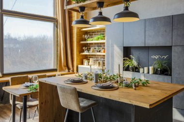 Büyük, rahat bir kır evinin içinde koyu renk bir çatı katı. Mutfak, dinlenme alanı ve yatak alanı olan açık planlı bir daire. Büyük pencereler ve ahşap dekorasyon