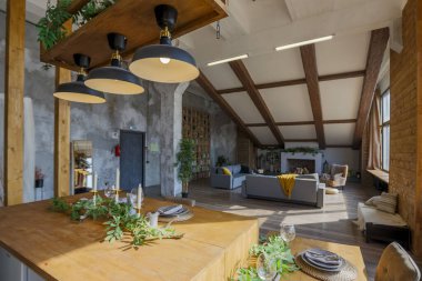 Büyük, rahat bir kır evinin içinde koyu renk bir çatı katı. Mutfak, dinlenme alanı ve yatak alanı olan açık planlı bir daire. Büyük pencereler ve ahşap dekorasyon