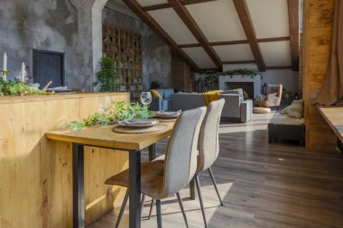 Büyük, rahat bir kır evinin içinde koyu renk bir çatı katı. Mutfak, dinlenme alanı ve yatak alanı olan açık planlı bir daire. Büyük pencereler ve ahşap dekorasyon