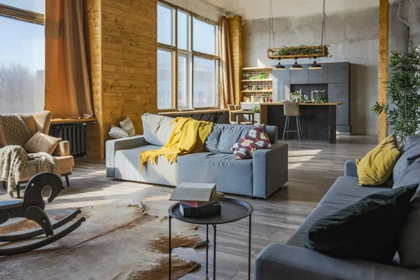 Dark loft style interior of big cozy country house. open plan apartment with kitchen area, rest zone and bed area. Huge windows and wooden decoration
