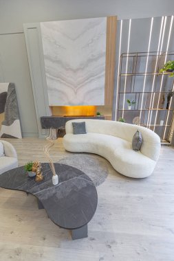 Modern stüdyo dairesinin içinde, ahşap elementli yeşil pastel renklerde lüks bir ev. Pahalı mobilyalar ve dekorasyonlar. Şöminenin yanındaki rahat oturma odası.