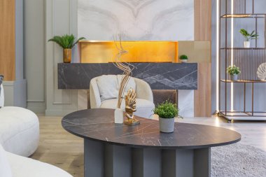 Modern stüdyo dairesinin içinde, ahşap elementli yeşil pastel renklerde lüks bir ev. Pahalı mobilyalar ve dekorasyonlar. Şöminenin yanındaki rahat oturma odası.