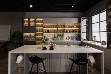 Son derece modern, koyu renkli, süper havalı ışıklandırması ve yemek pişirmek için bir adası olan bir dairede lüks bir mutfak.