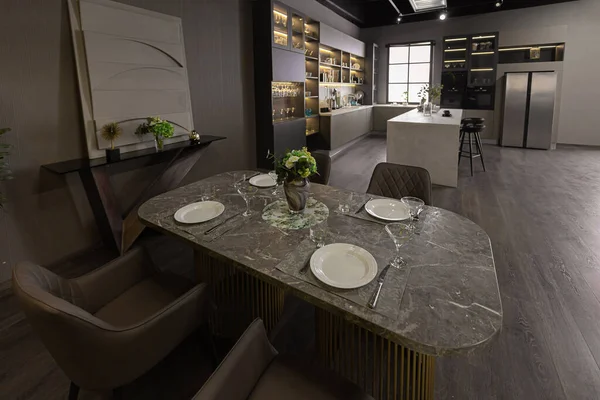 时尚奢华的厨房内部在一个超现代的宽敞的公寓黑暗的颜色 超级凉爽的引导照明和一个岛做饭和餐桌面积 — 图库照片
