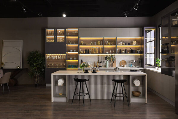 стильный роскошный интерьер кухни в ультра-современной просторной квартире в темных тонах с супер холодным освещением и островом для приготовления пищи
