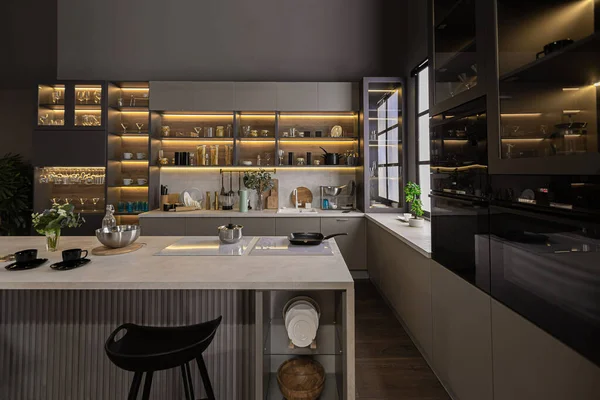 暗い色の超近代的な広々としたアパートメントでスタイリッシュな高級キッチンインテリアスーパークールな照明と料理のための島 — ストック写真