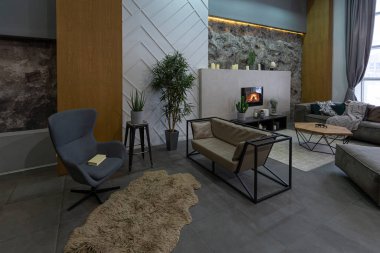 Gri renkli dekoratif taş duvarlı modern bir stüdyo. Odanın tasarımında taş ahşap, fayanslar ve kurşun aydınlatma