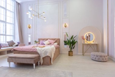 Pahalı, ferah, aydınlık, şık bir dairenin lüks, modern yatak odası. döşenmiş mobilyalar ve dekoratif ışıklandırma, yumuşak pastel renkler ve rahat atmosfer