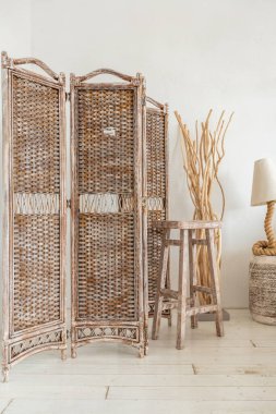 Oturma odasının modayla döşenmiş geniş bir odası var. Büyük pencereler ve şık hasır ışıklı mobilyalar. Etnik dekor bolluğu