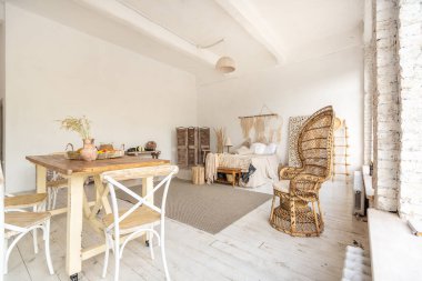 Oturma odasının modayla döşenmiş geniş bir odası var. Büyük pencereler ve şık hasır ışıklı mobilyalar. Etnik dekor bolluğu