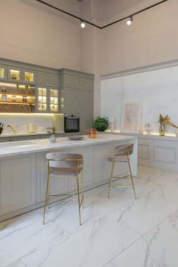 Yumuşak pastel renkli rahat bir stüdyonun ultra modern zarif iç mekânındaki son moda ev trendleri. Yemek pişirmek için bir adası olan şık bir mutfağın yakın çekimleri