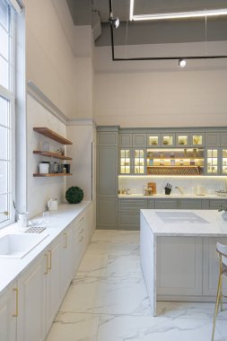 Yumuşak pastel renkli rahat bir stüdyonun ultra modern zarif iç mekânındaki son moda ev trendleri. Yemek pişirmek için bir adası olan şık bir mutfağın yakın çekimleri