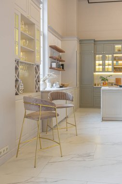 Yumuşak pastel renkli rahat bir stüdyonun ultra modern zarif iç mekânındaki son moda ev trendleri. Yemek pişirmek için bir adası olan şık bir mutfağın yakın çekimleri