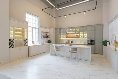 Yumuşak pastel renkli rahat bir stüdyonun ultra modern zarif iç mekânındaki son moda ev trendleri. Yemek pişirmek için bir adası olan şık bir mutfağın yakın çekimleri