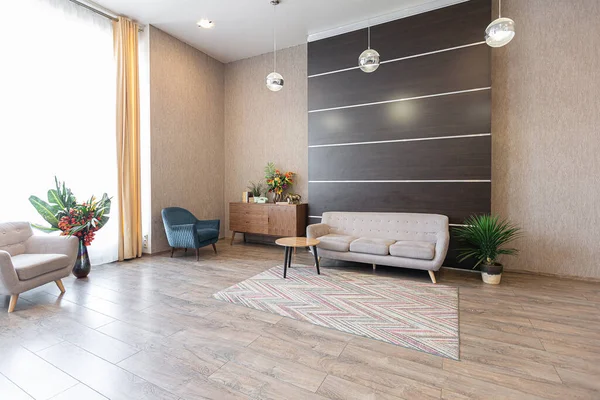 柔らかい暖かい色の広々としたスタジオの現代的な通常のデザイン シンプルな家具 日光のある明るい大きな部屋 昼間だ タイル張りの茶色の床と白い壁 — ストック写真