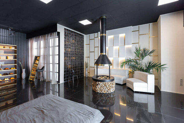 темный современный стильный мужской интерьер квартиры с освещением, декоративными стенами, камином, гардеробной и огромным окном