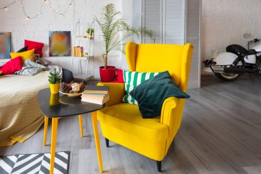 İskandinav tarzı, parlak sarı mobilyalı ve yeni yıl ışıklarıyla süslenmiş stüdyo dairesinin son moda moda iç tasarımı..