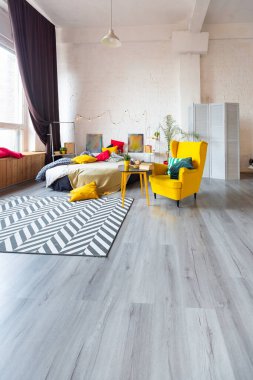 İskandinav tarzı, parlak sarı mobilyalı ve yeni yıl ışıklarıyla süslenmiş stüdyo dairesinin son moda moda iç tasarımı..
