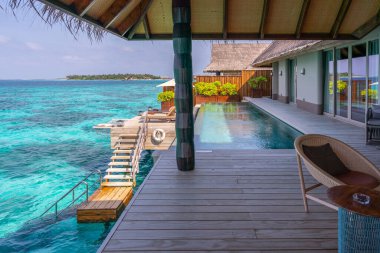 Maldivler 'deki çok pahalı ve doğal ahşap süslemelerle süslenmiş zengin bir su villasının lüks dış cephesi..