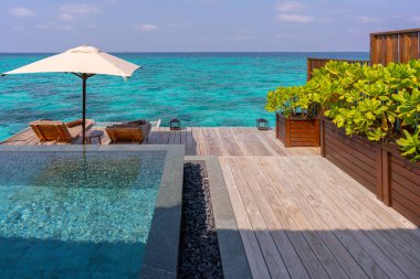 Maldivler 'deki çok pahalı ve doğal ahşap süslemelerle süslenmiş zengin bir su villasının lüks dış cephesi..