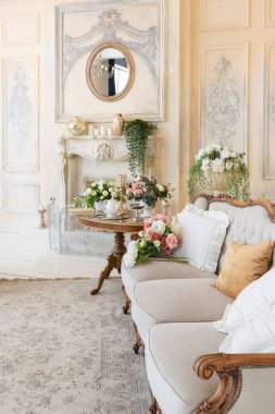 İçi bej renkli, zengin oturma odası. Barok tarzı antika pahalı mobilyalar. Duvarlar sıva ve fresklerle süslenmiş.