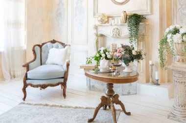 İçi bej renkli, zengin oturma odası. Barok tarzı antika pahalı mobilyalar. Duvarlar sıva ve fresklerle süslenmiş.