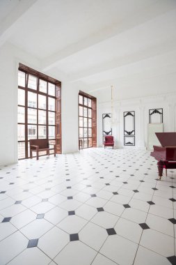 Benzersiz iç ile büyük lüks beyaz salonu. Siyah ve beyaz fayans zemin, siyah ve beyaz sıva duvarlar, ayna Mozaik, üç metrelik kristal bir avize sarkacak ve piyano ile yüksek şömine