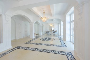 Güzel, şık, zengin, parlak, boş bir iç mekan. Yerden geniş pencereli yüksek beyaz duvarlar. Yerdeki desen.