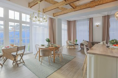 Modern, pahalı, lüks, açık planlı bir daire. Tavanda pastel renkli ahşap kirişler olan zengin İskandinav tarzı iç mekan.