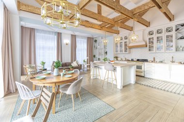 Modern, pahalı, lüks, açık planlı bir daire. Tavanda pastel renkli ahşap kirişler olan zengin İskandinav tarzı iç mekan.