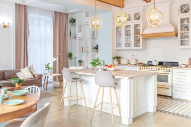 Modern, pahalı, lüks, açık planlı bir daire. Tavanda pastel renkli ahşap kirişler olan zengin İskandinav tarzı iç mekan.