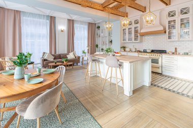 Modern, pahalı, lüks, açık planlı bir daire. Tavanda pastel renkli ahşap kirişler olan zengin İskandinav tarzı iç mekan.