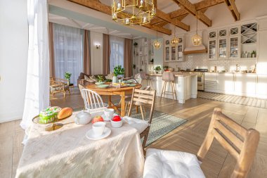 Modern, pahalı, lüks, açık planlı bir daire. Tavanda pastel renkli ahşap kirişler olan zengin İskandinav tarzı iç mekan.