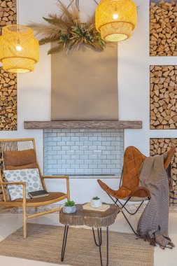 Tavan arasında ahşap sütunlar olan, tuğla, mermer, ahşap, şık mobilyalar ve beyaz duvarlarla süslenmiş, aydınlık bir stüdyo dairesinin modern iç mimarisi.