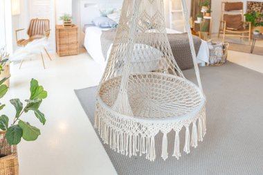 Tavan arasında ahşap sütunlar olan, tuğla, mermer, ahşap, şık mobilyalar ve beyaz duvarlarla süslenmiş, aydınlık bir stüdyo dairesinin modern iç mimarisi.