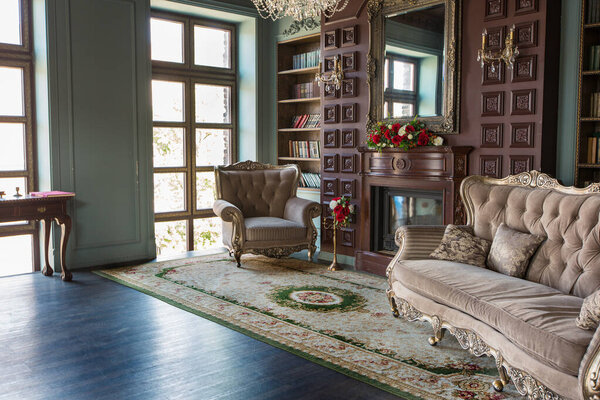 Роскошный интерьер домашней библиотеки. Гостиная с элегантной мебелью
