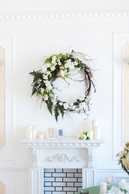 Oturma odasının ışıl ışıl, lüks bir tasarımı var. Süslerle süslenmiş beyaz duvarlar. Şömine. İçeriden kimse yok. Tabakların, mumların ve çiçek buketlerinin olduğu masa..