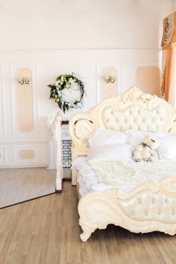 Oturma odasının ışıl ışıl, lüks bir tasarımı var. Süslerle süslenmiş beyaz duvarlar. Şömine. İçeriden kimse yok. Tabakların, mumların ve çiçek buketlerinin olduğu masa..