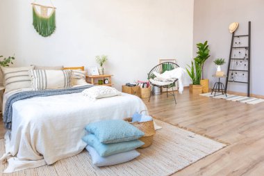 Şık bir çatı katının içinde. Geniş pencereli, yerde parke ve aydınlık duvarlı geniş bir daire. Dekorasyon için farklı küçük şeylerle rafların yakın görüntüsü