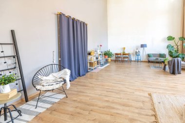 Şık bir çatı katının içinde. Geniş pencereli, yerde parke ve aydınlık duvarlı geniş bir daire. Dekorasyon için farklı küçük şeylerle rafların yakın görüntüsü