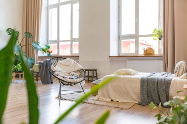 Şık bir çatı katının içinde. Geniş pencereli, yerde parke ve aydınlık duvarlı geniş bir daire. Dekorasyon için farklı küçük şeylerle rafların yakın görüntüsü