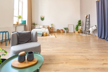 Şık bir çatı katının içinde. Geniş pencereli, yerde parke ve aydınlık duvarlı geniş bir daire. Dekorasyon için farklı küçük şeylerle rafların yakın görüntüsü