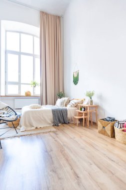 Şık bir çatı katının içinde. Geniş pencereli, yerde parke ve aydınlık duvarlı geniş bir daire. Dekorasyon için farklı küçük şeylerle rafların yakın görüntüsü